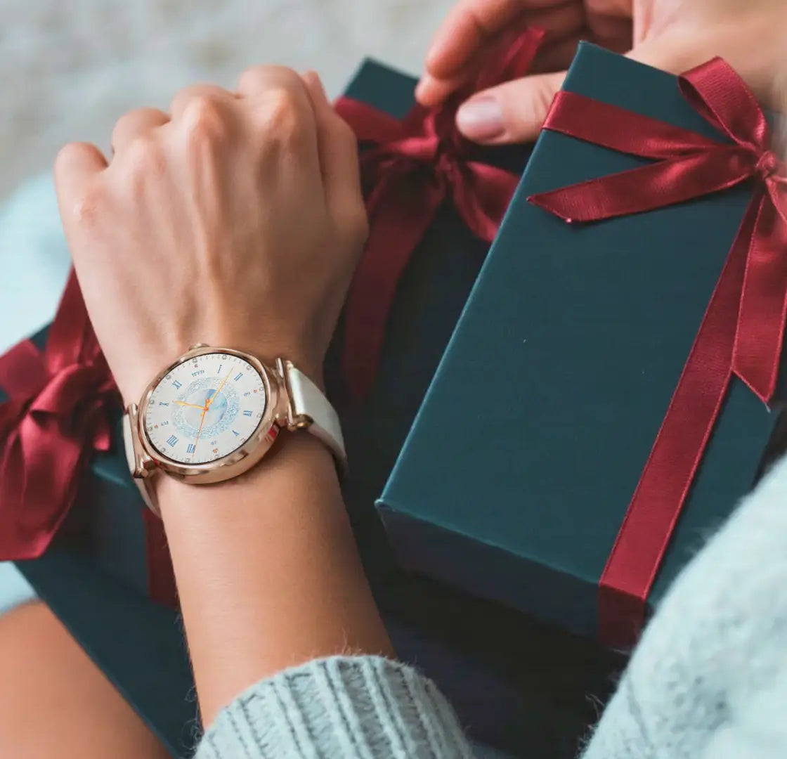 runmefit grace smart watch for women displayed on wrist next to elegantly wrapped gift boxes